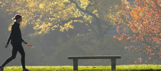 Woman walking with fall leaves in background